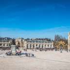 Ein großer quadratischer platz mit vielen menschen und einem großen gebäude im hintergrund