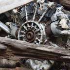 Ein verrosteter Motor sitzt auf einem Haufen Holz