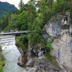 Menschen gehen auf einer Brücke über einen Fluss