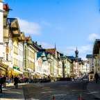 Eine Stadtstraße mit vielen Geschäften und einem Gebäude mit der Aufschrift " apotheke "
