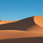 Eine Sanddüne mit einem blauen Himmel dahinter