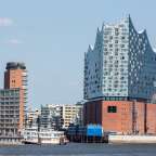 Ein großes Gebäude mit vielen Fenstern sitzt über einem Fluss