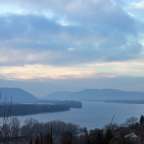 Ein Fluss mit Bergen im Hintergrund und einem bewölkten Himmel