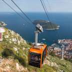 Eine Seilbahn fährt auf einem Berg über eine Stadt