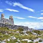 Ein paar ruinen stehen auf einem grasbewachsenen hügel