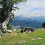 Ein Tisch und Stühle stehen auf einer Wiese mit Blick auf die Berge
