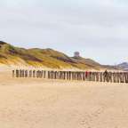 Eine Reihe von Holzpfosten auf einem Sandstrand