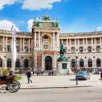 Ein Pferd zieht einen Wagen vor einem großen Gebäude