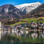 Eine kleine Stadt an einem See mit Bergen im Hintergrund