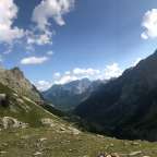Eine Berglandschaft mit einem blauen Himmel und weißen Wolken