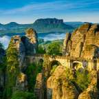 Eine Brücke führt zwischen zwei Felsen in einem Tal