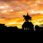 Eine Silhouette einer Statue eines Mannes auf einem Pferd bei Sonnenuntergang