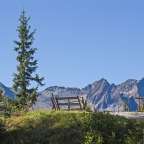 Ein Holzzaun steht auf einem Hügel mit Blick auf die Berge