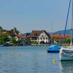 Ein Boot mit einem blauen Zelt sitzt am Ufer eines Sees