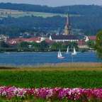 Ein paar Boote fahren auf einem See mit einer Kirche im Hintergrund