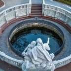 Eine Statue steht in einem Kreis um einen Teich