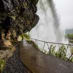 Ein Wasserfall stürzt auf einen Gehweg hinunter