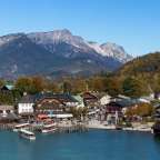 Ein kleines Dorf an einem See mit Bergen im Hintergrund