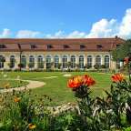 Ein großes Gebäude mit vielen Fenstern in einem Garten