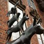 Eine Statue von drei Tieren steht vor einem Backsteingebäude