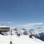 Ein Gebäude auf einem schneebedeckten Berg mit Bergen im Hintergrund