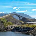 Eine Brücke über einen Fluss mit Bergen im Hintergrund