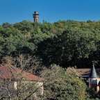 Ein Turm sitzt auf einem Hügel über einem Dorf