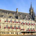 Ein großes Gebäude mit vielen Fenstern und roten Fensterläden