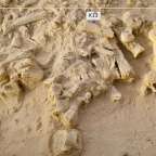 Ein weißes Schild mit der Aufschrift k13 hängt an einem Stück Sand