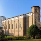 Ein Backsteingebäude mit vielen Fenstern und einem Turm