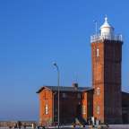 Ein rotes Backsteingebäude mit einem weißen Leuchtturm darauf