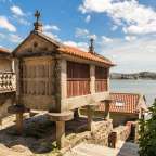 Ein Steingebäude mit einem Holzdach und einem Kreuz darauf