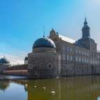 Ein großes Schloss mit einem großen Teich davor