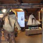 Ein Mann steht in einem Museum neben einem Segelschiff