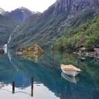 Ein Boot schwimmt in einem See mit Bergen im Hintergrund