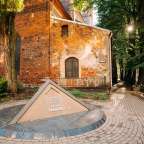 Ein kleines Denkmal in der Nähe einer alten Backsteinkirche