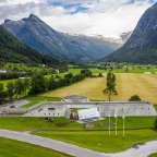 Ein großes Gebäude inmitten eines grünen Tals mit Bergen im Hintergrund