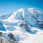 Eine Gruppe von Menschen steht vor einem schneebedeckten Berg