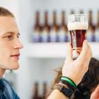 Ein Mann hält ein Glas Bier in der Hand