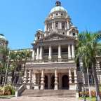 Ein großes Gebäude mit vielen Stufen und Palmen davor