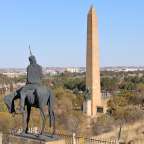 Eine Statue eines Mannes auf einem Pferd neben einem Obelisk
