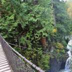Eine Hängebrücke über einen Wasserfall im Wald
