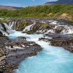 Ein Fluss fließt zwischen Felsen und Bäumen