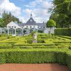 Ein labyrinthförmiger Garten mit einem großen Gebäude im Hintergrund
