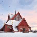 Eine rote Kirche mit schneebedecktem Dach