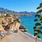 Ein Strand mit Bäumen und Bergen im Hintergrund