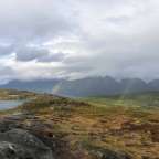 Ein Regenbogen scheint über einen Bergsee in den Bergen