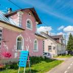 Ein rosa Haus mit einem blauen Schild davor