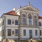 Ein weißes Gebäude mit einem roten Dach und vielen Fenstern