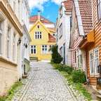 Eine schmale Straße mit einem gelben Haus in der Mitte